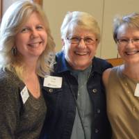 Three alumnae pose for a photo